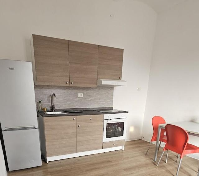 a kitchen with a white refrigerator and a table and chairs at b apartments in Case Bruciate