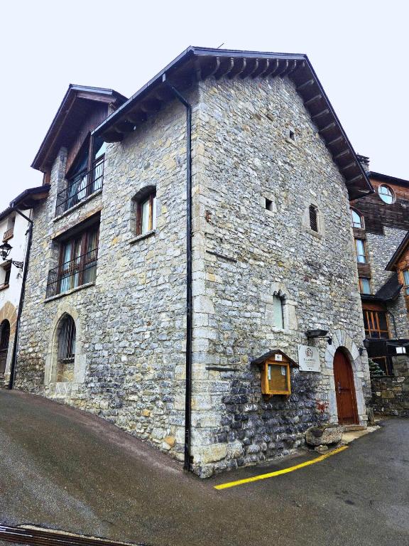a large stone building with a door on the side of it at HOTEL EL Alboroque in Tramacastilla de Tena