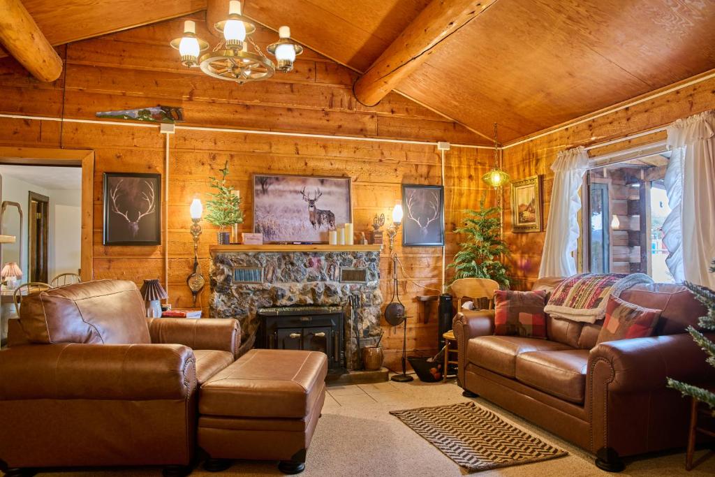 a living room with leather furniture and a fireplace at Milner Pass Cabin Retreat in South Fork