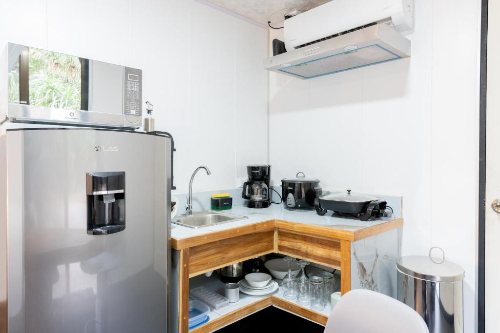a small kitchen with a stainless steel refrigerator at Pura Vida Rent in Nosara