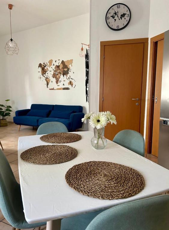 a table with four chairs and a vase of flowers on it at La casetta triangolare in Bernalda