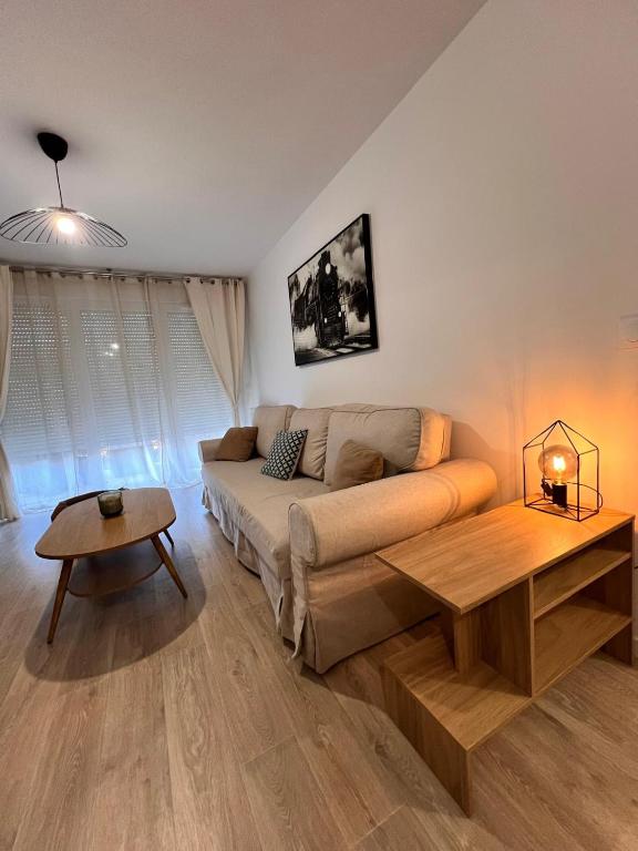 a living room with a couch and a table at T2 Cosy avec Terrasse & 2 parkings privés in Saint-André-de-Cubzac