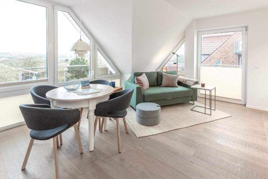 a living room with a table and chairs and a couch at Lee in Juist