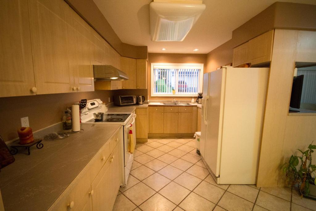 eine Küche mit einem weißen Kühlschrank und einem Fenster in der Unterkunft Eagle Close Executive B&B in Prince Rupert