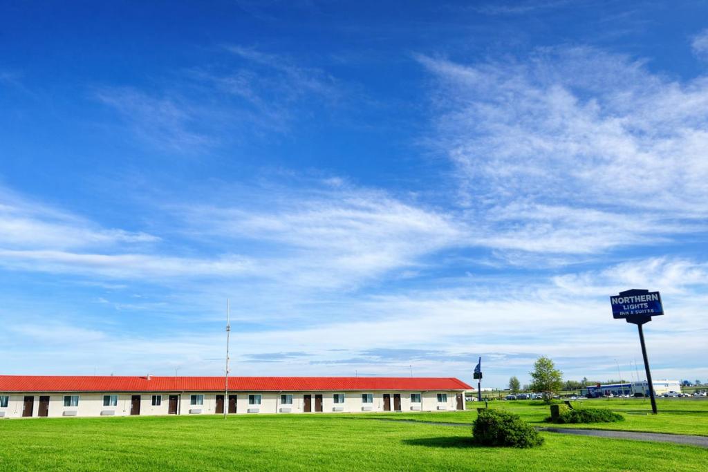 a building with a sign in the middle of a field at Northern Lights Inn & Suites in Valleyview