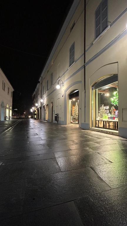 an empty street at night with a building at Maison Cavallino in Lugo