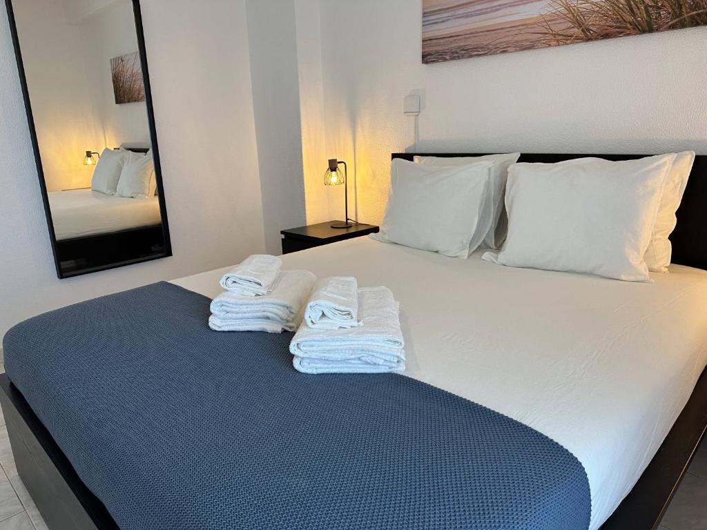 a bedroom with a bed with towels on it at Go4Portugal - Dinis - Luxe Condo with Pool, Airco, Seaview with two Balcony in Albufeira