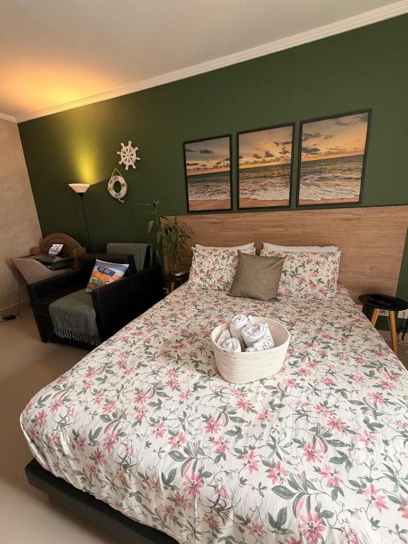 a bedroom with a large bed with a basket on it at Flat Romance Praia e Home Office in São Vicente