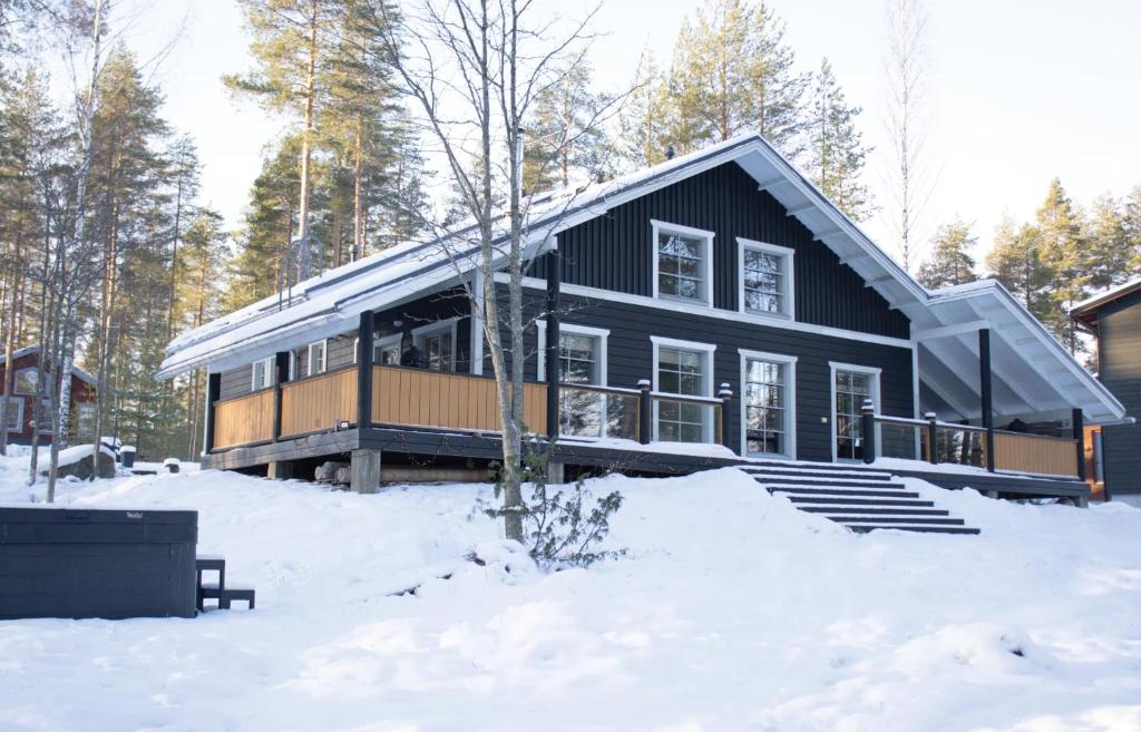 a black house in the snow in the woods at Koliwood B in Kolinkylä