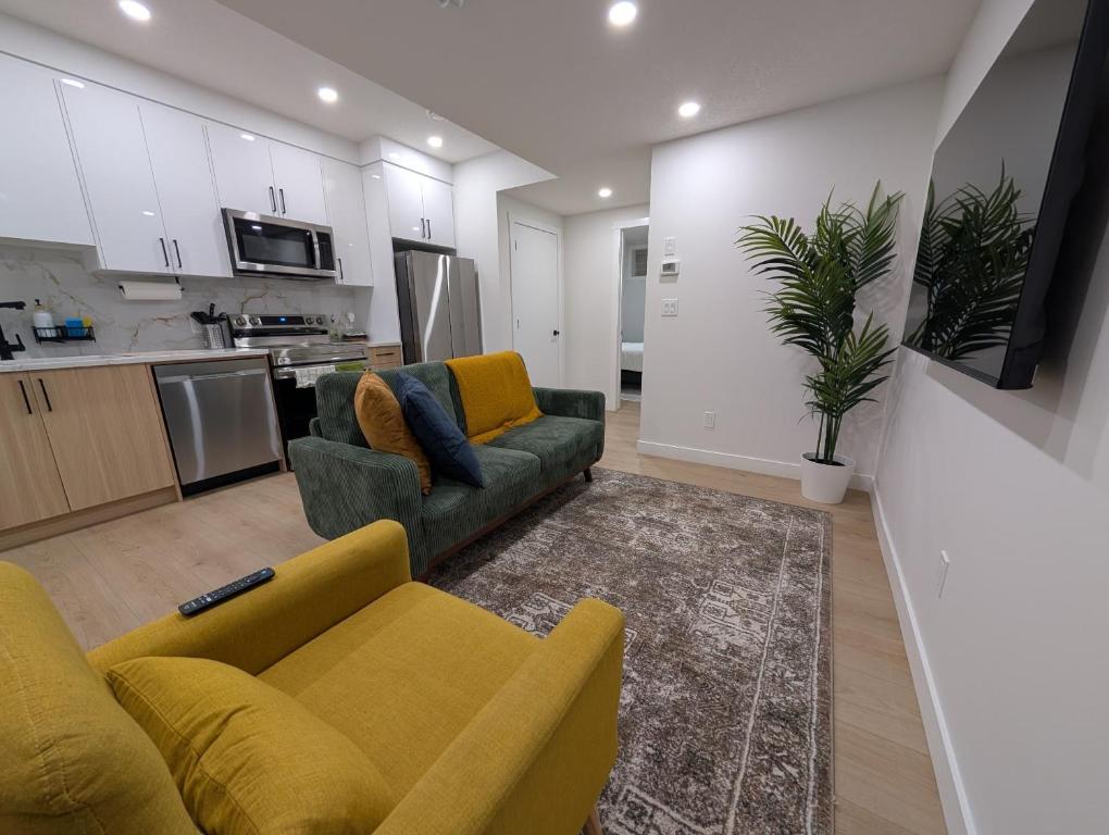 a living room with two couches and a kitchen at Granny's Hug, a cozy 2 Bedroom Basement Suite in Calgary
