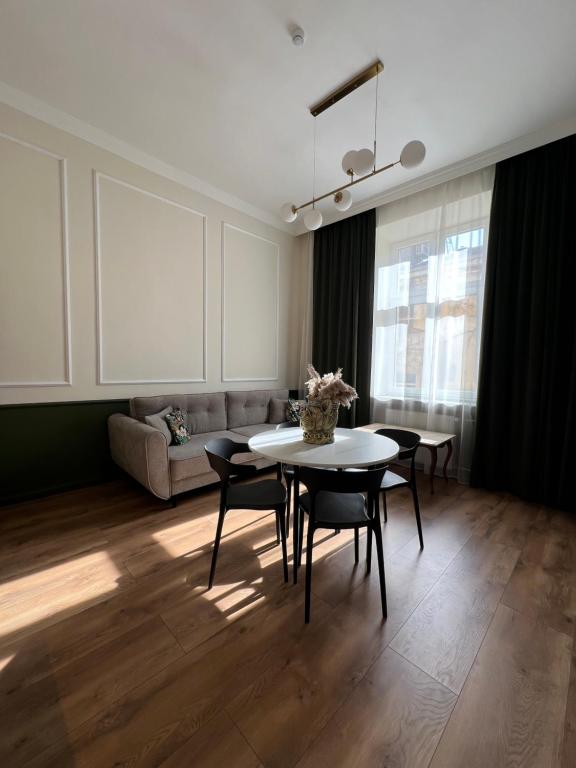a living room with a table and chairs and a couch at Apartments Piotrkowska 67 in Łódź