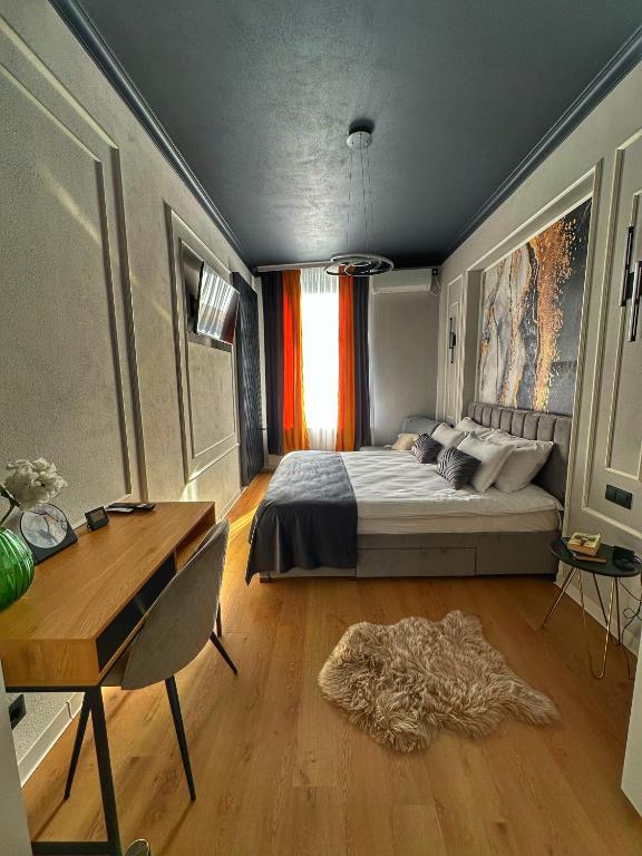a bedroom with a bed and a desk and a desk at Euphoria Apartments in Beiuş