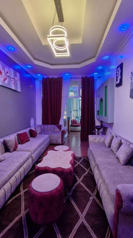 a large living room with couches and tables and blue lights at TANG HOSPITALITY Services in Gisenyi