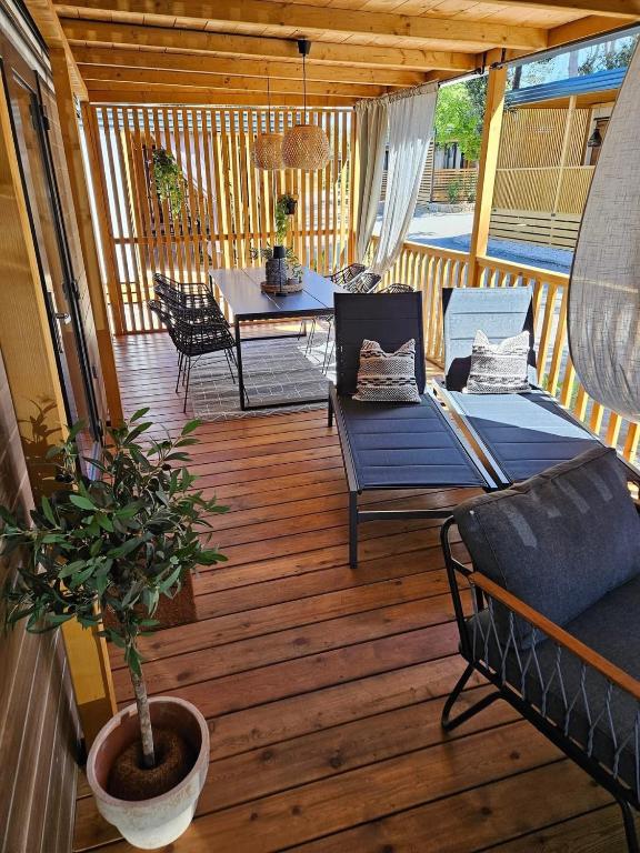 a porch with a couch and a table on a deck at Max Mobile Home in Biograd na Moru