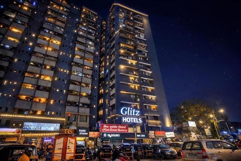 a tall building with cars parked in front of it at Glitz Saineel Executive Near Juhu Beach in Mumbai