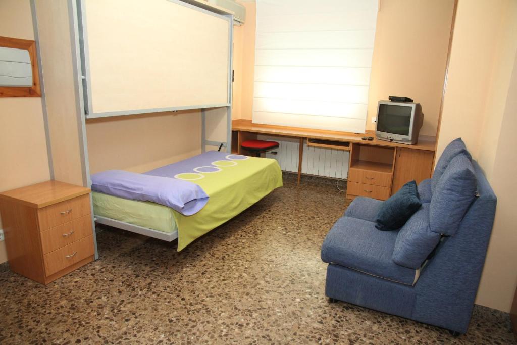a bedroom with a bed and a chair and a desk at ApartamentosAlquilerZaragoza in Zaragoza