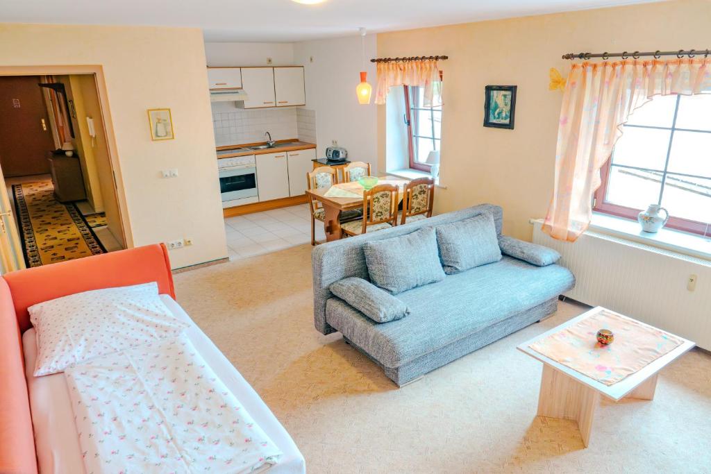 a living room with a blue couch and a table at Ferienwohnung 2 "Zum Feld" auf dem Alpakahof in Bernstadt