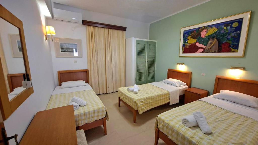a hotel room with two beds and a table at Kathrin apartments in Ipsos