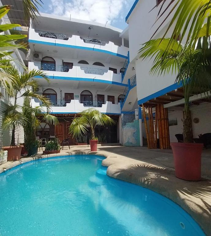 a swimming pool in front of a building at Hotel Piedra del Mar in Puerto López