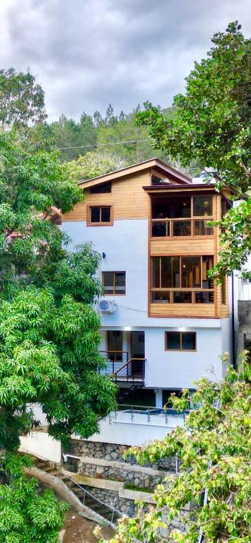 a building with a tree in front of it at Riverfront Paradise Villa River front Villa in Jarabacoa
