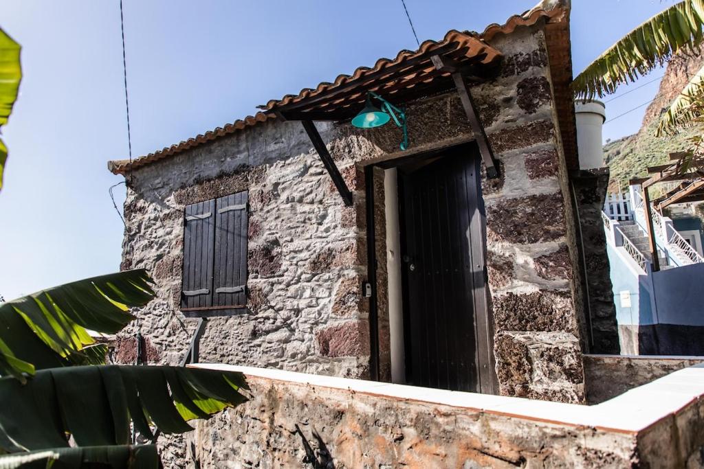 a stone house with a door and a window at Casinha da Vereda by Rent-a-key in Paul do Mar