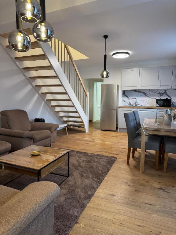 a living room with a couch and a table and a kitchen at Luxury Comfort Home in Anklam