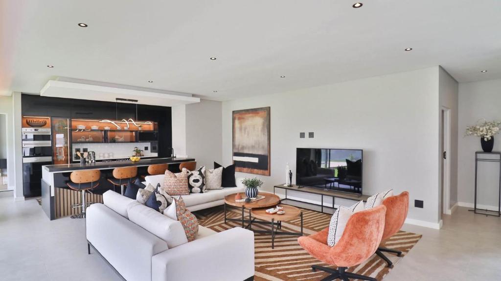 a living room with white furniture and a kitchen at Pops lifestyle in Sandton