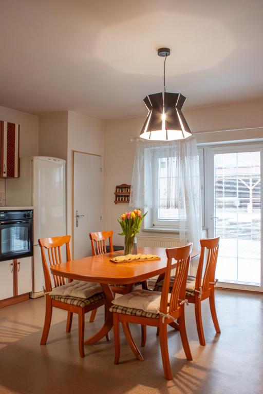 a dining room with a wooden table and chairs at Apartmán se společným bazénem Zlonice in Zlonice