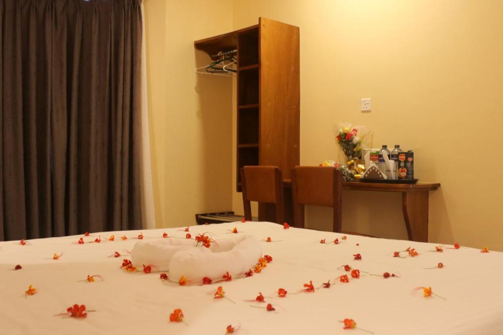 a bed with red flowers on top of it at Paran Amboseli Resort in Kimana