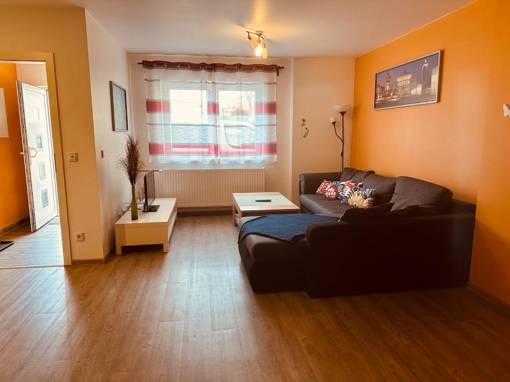 a living room with a couch and a table at StayHere24 Große Monteur- und Ferienwohnung am Auenwald in Schkeuditz