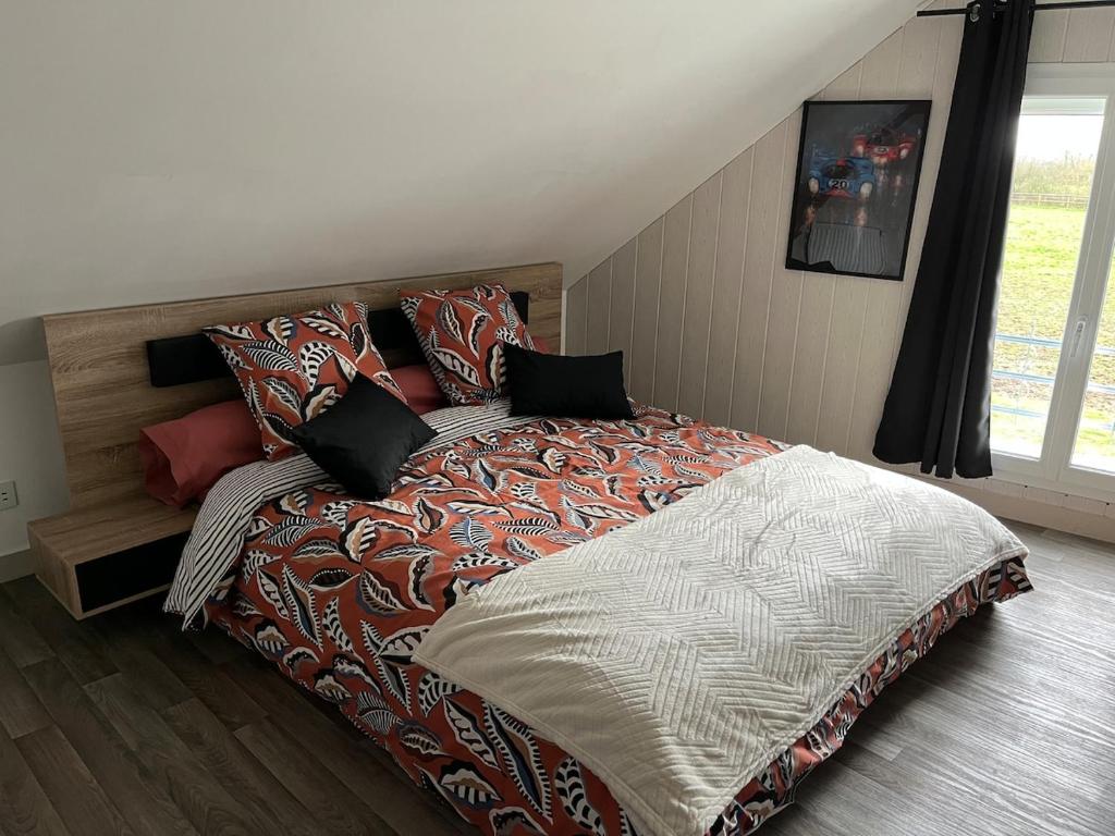 a bedroom with a large bed with pillows on it at Logement indépendant à la campagne proche du Pôle européen du Cheval et Circuit des 24h du Mans in Courceboeufs