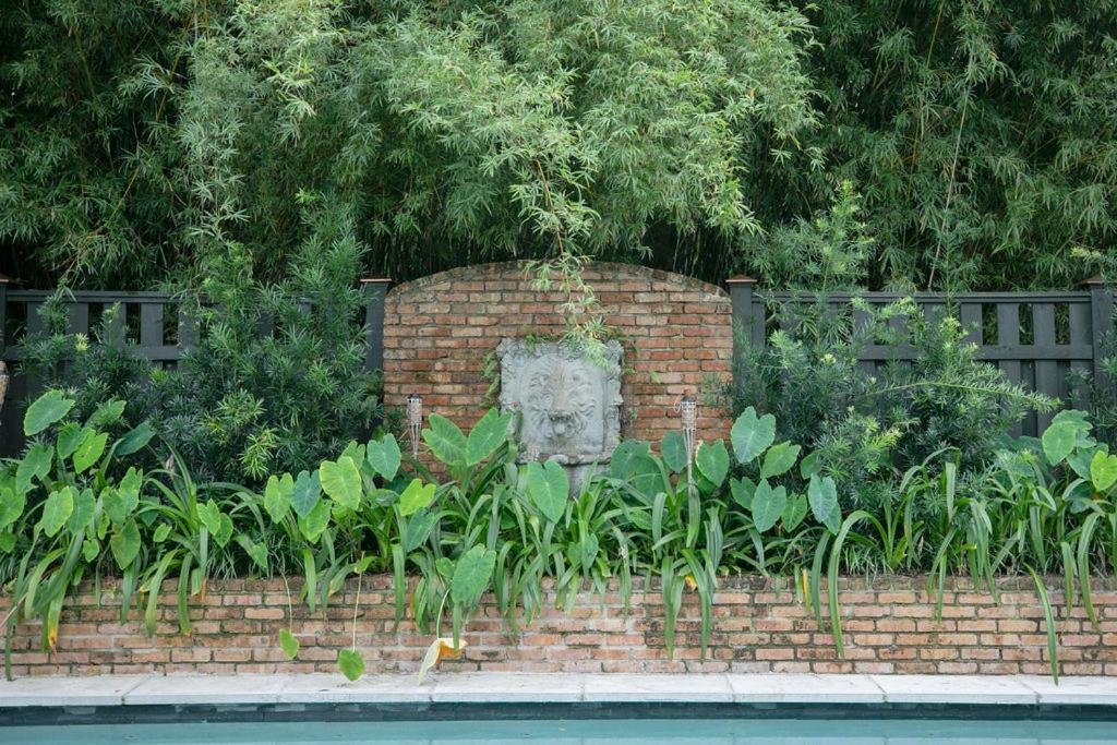 a brick wall with a statue in a garden at Marée Mason in Ocean Springs