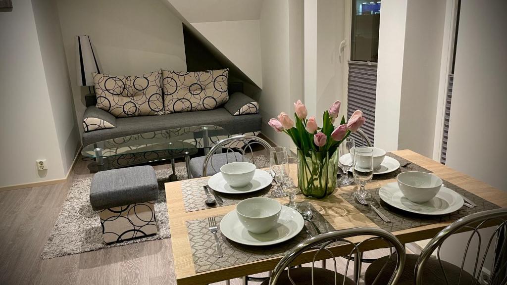 a dining room table with a vase of flowers on it at Veløyveien 4b in Sandefjord