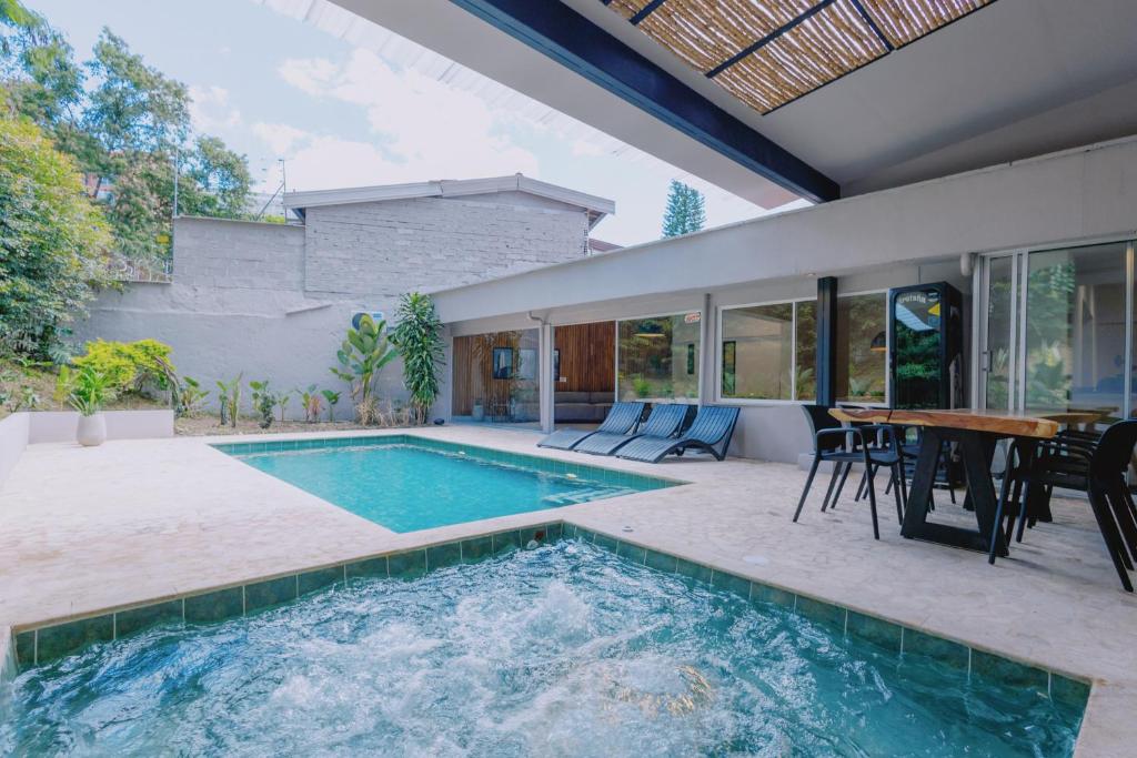 a swimming pool in a house with a table and chairs at Casa Palma in Medellín