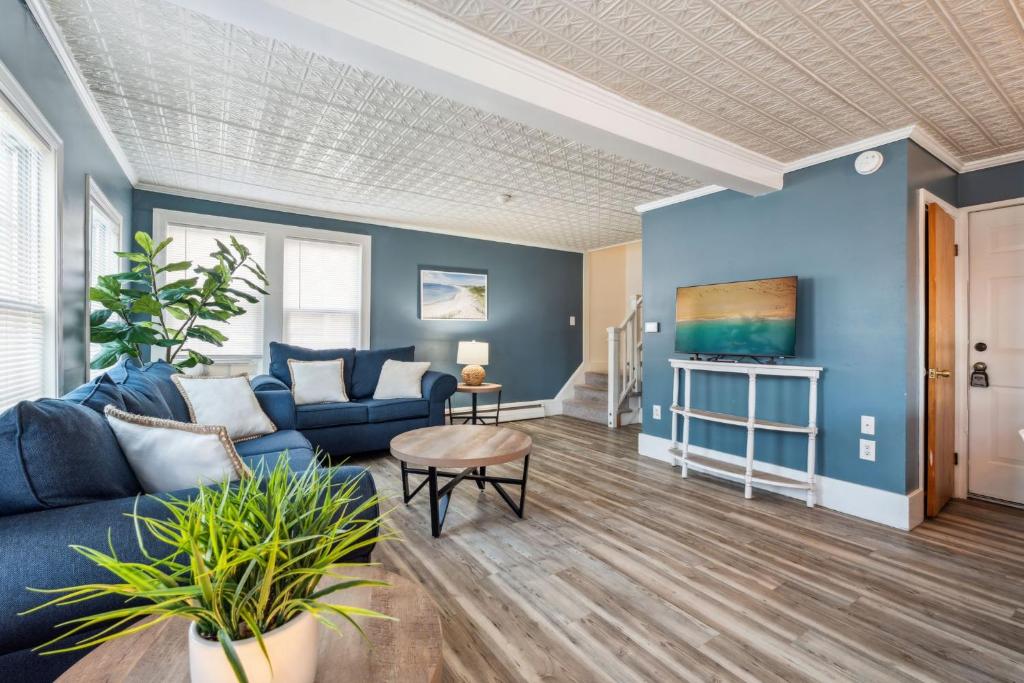 a living room with blue walls and a blue couch at Steps to Beach Pet Friendly Front Unit in Hampton