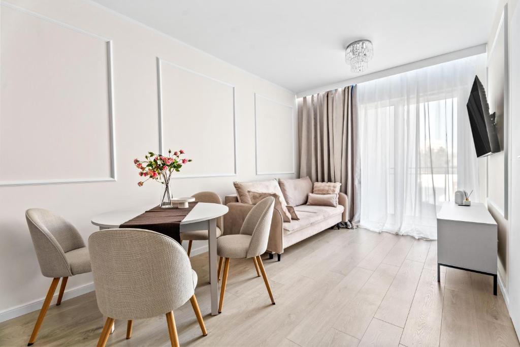 a living room with a couch and a table and chairs at MDM Apartments in Gdańsk