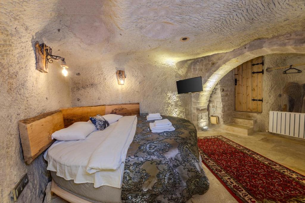 a bedroom with a bed in a stone room at Lubberona Cave Cappadocia in Nar