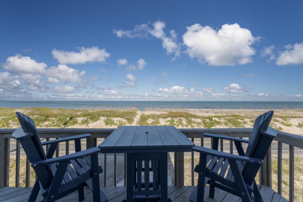 a table and chairs on a deck with the beach at 4785 - Paradise Found in Kitty Hawk