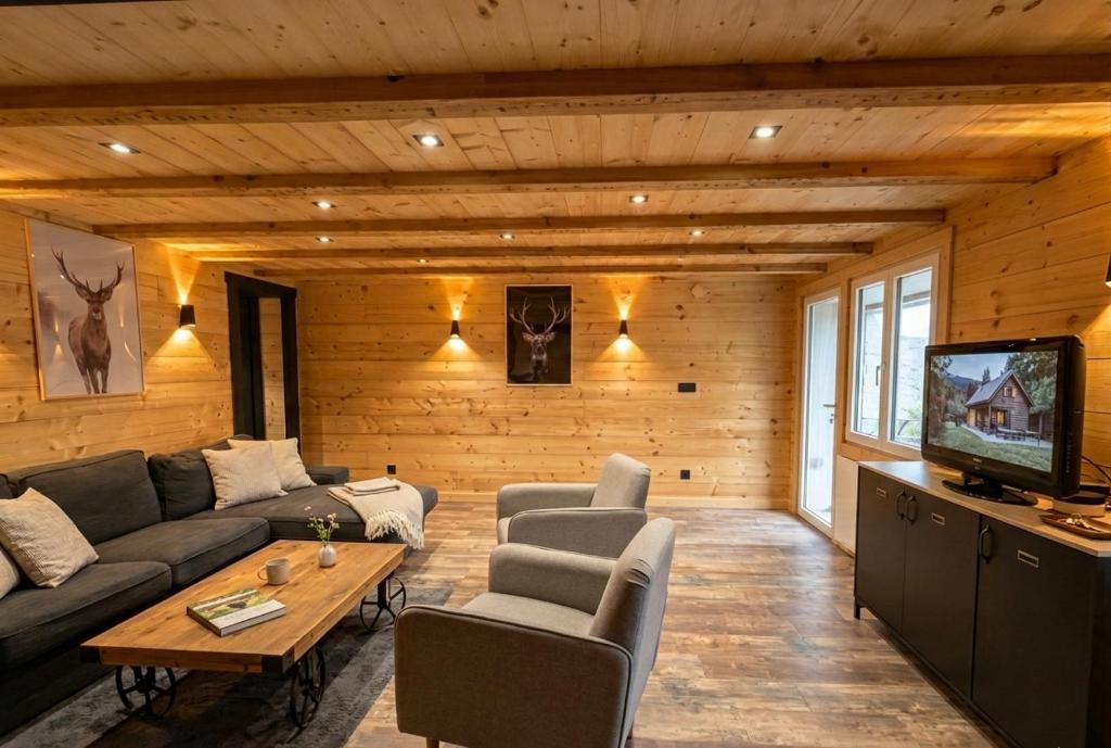 a living room with a couch and a tv at La Clochette d'Hiver Familial et espace Détente in Cornimont