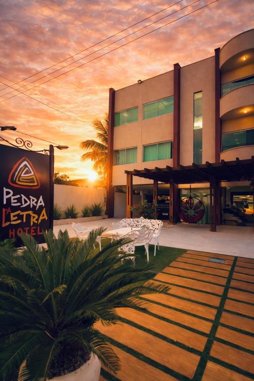 a hotel with tables and chairs in front of a building at Hotel Pedra da Letra in Mauriti