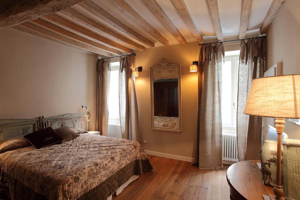 a bedroom with a bed and a table with a lamp at PIO Rooms b&b Parma in Parma