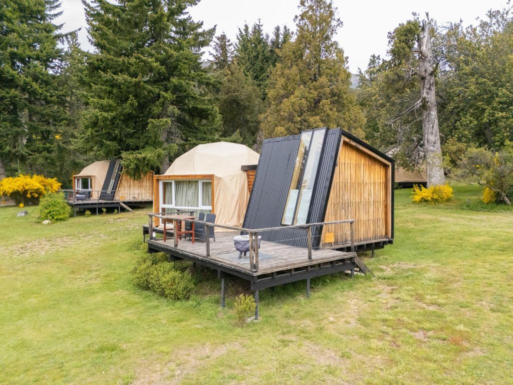 a yurt with a deck in a field with trees at Glamping Vulcanche in Villa Traful