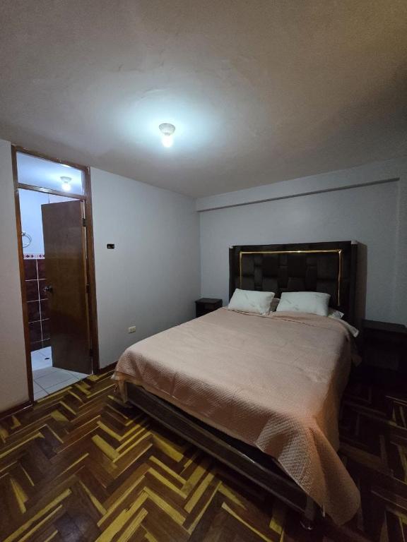a bedroom with a large bed and a sliding glass door at Candela Apartment PUNO in Puno