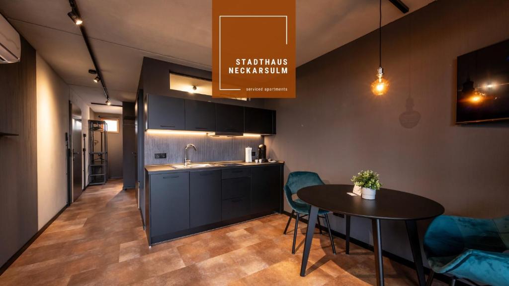 a kitchen and dining room with a table and chairs at Stadthaus Neckarsulm serviced apartments - Stadthaus Heiner in Neckarsulm