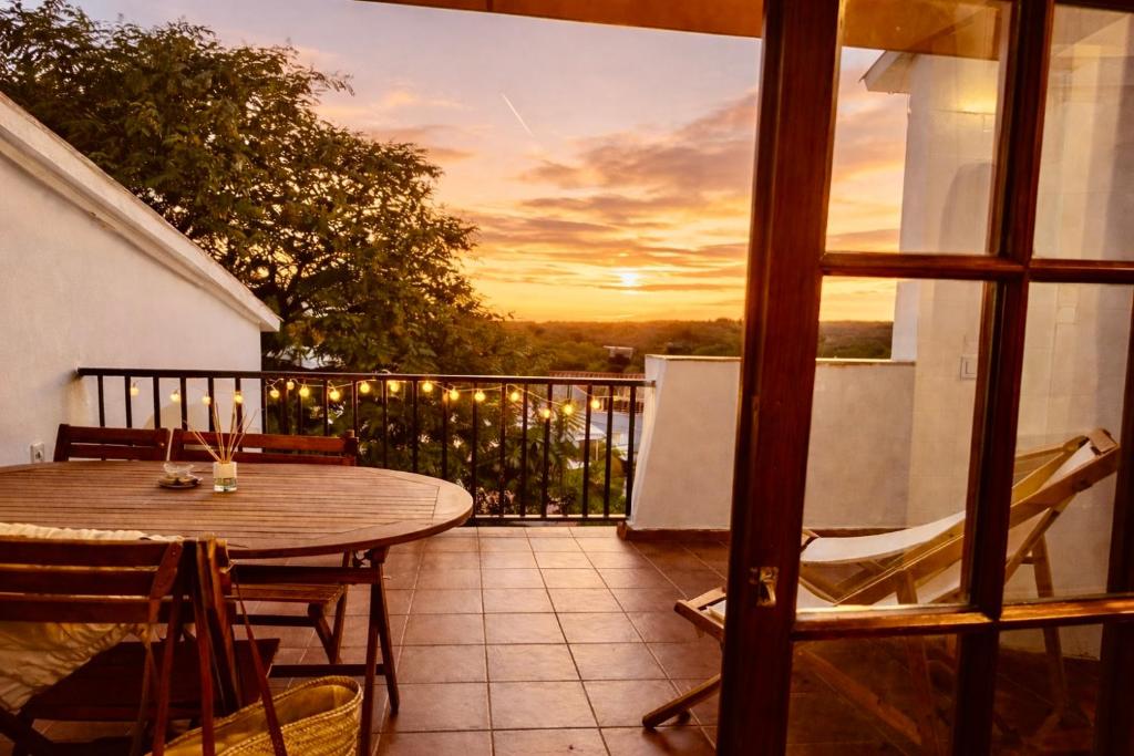 a patio with a table and chairs on a balcony at EcoHome Menorca in Cala en Porter