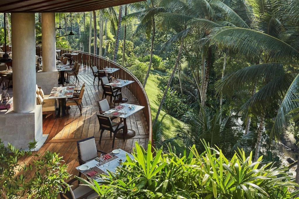 a restaurant with tables and chairs on a wooden deck at Four Seasons Resort Bali at Sayan in Ubud