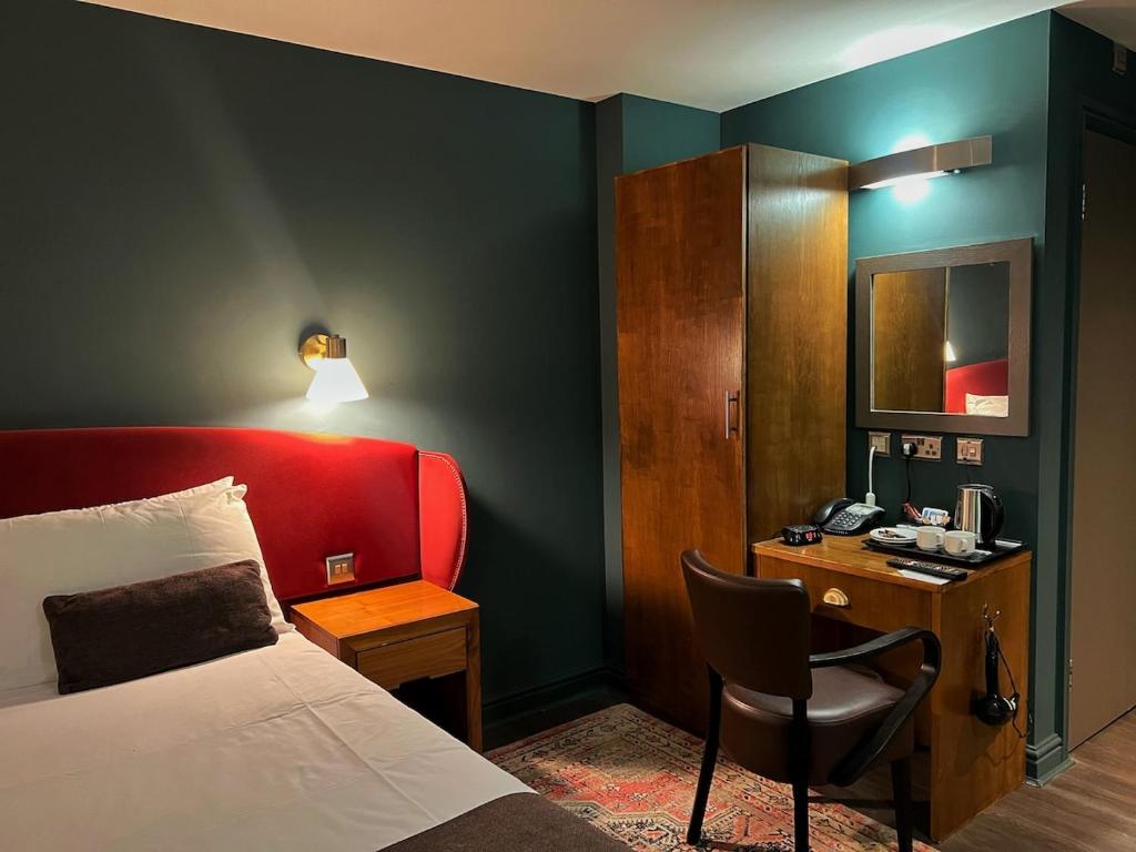 a hotel room with a bed and a desk and a chair at HNFC Stays - Harmony Accommodation in Elswick