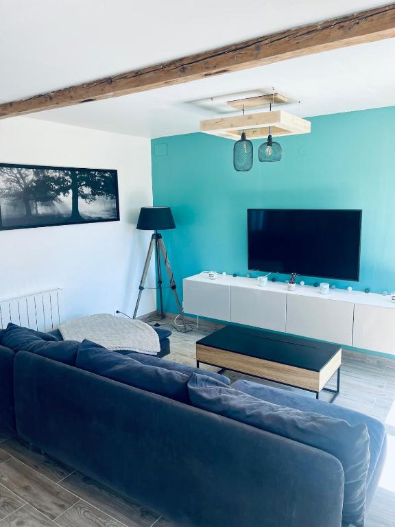 a living room with a couch and a flat screen tv at Maison avec Jacuzzi - Europa-Park in Obenheim