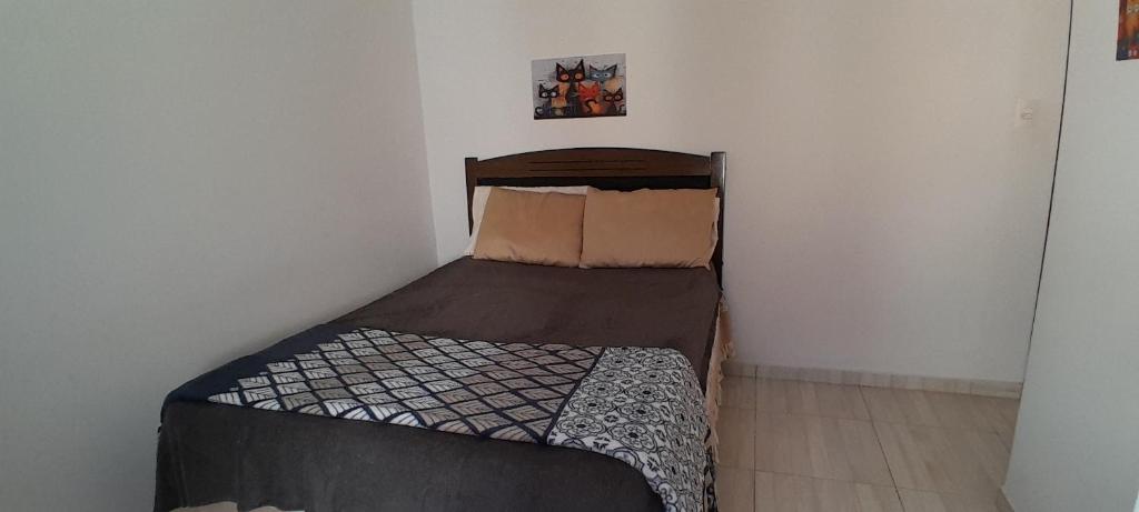 a small bedroom with a bed in a room at Suíte aconchego in Guaratuba