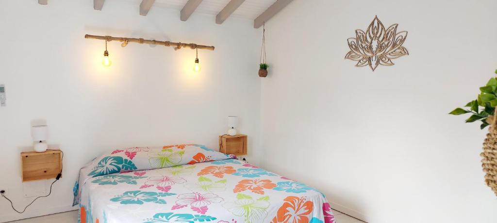 a bedroom with a bed with a flowered blanket at Ti Cactus Guadeloupe in Sainte-Rose